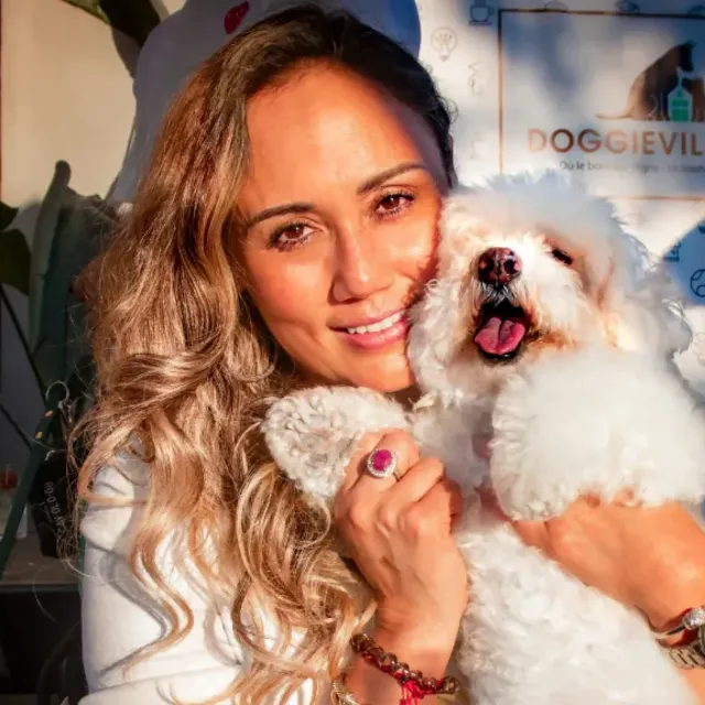 Doggieville MTL founder Tatiana Custode hugging Ruby the Bichon Frise