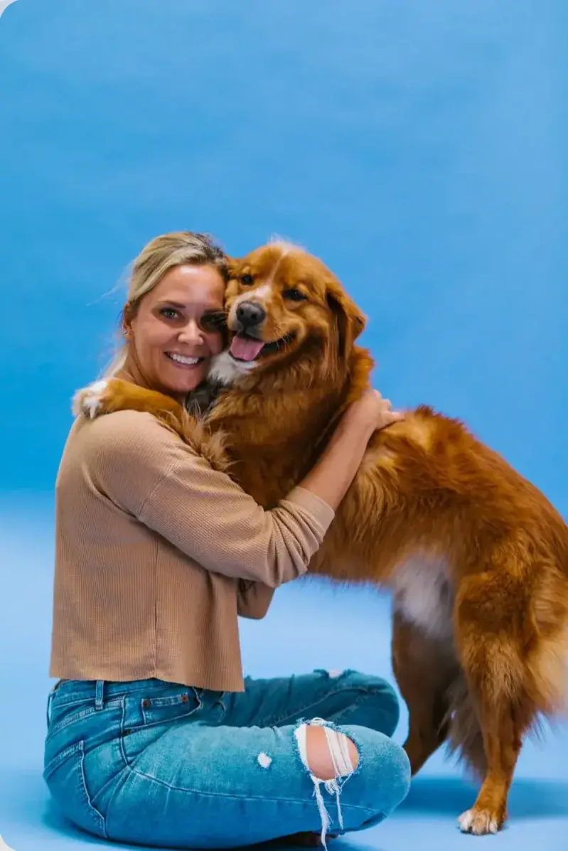 Membre de la Paw Crew qui serre un golden retriever dans ses bras