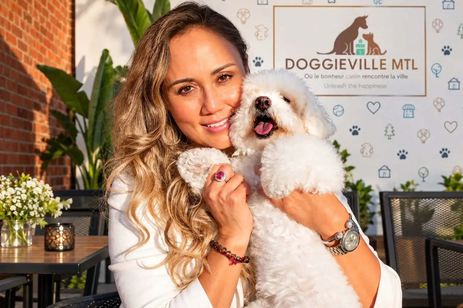 Tatiana Custode, founder of Doggieville MTL, hugging her Bichon Frise Ruby